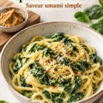 Une assiette d'orecchiette crémeuses aux épinards et miso, présentée avec des herbes fraîches.