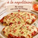 Milanesa napolitaine garnie de fromage, servie avec des accompagnements colorés.